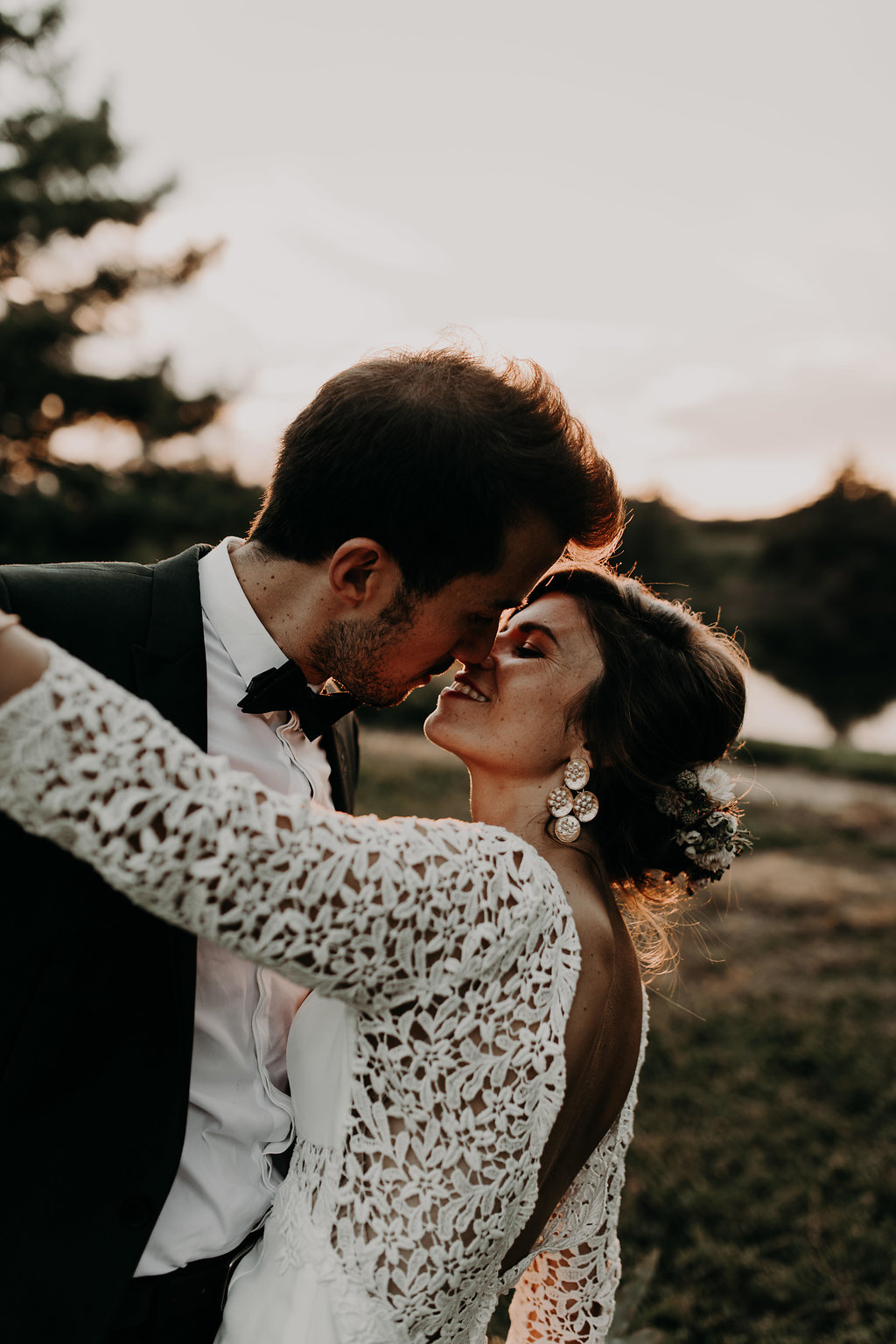 Couple de mariés qui danse au couché du soleil le jour du mariage