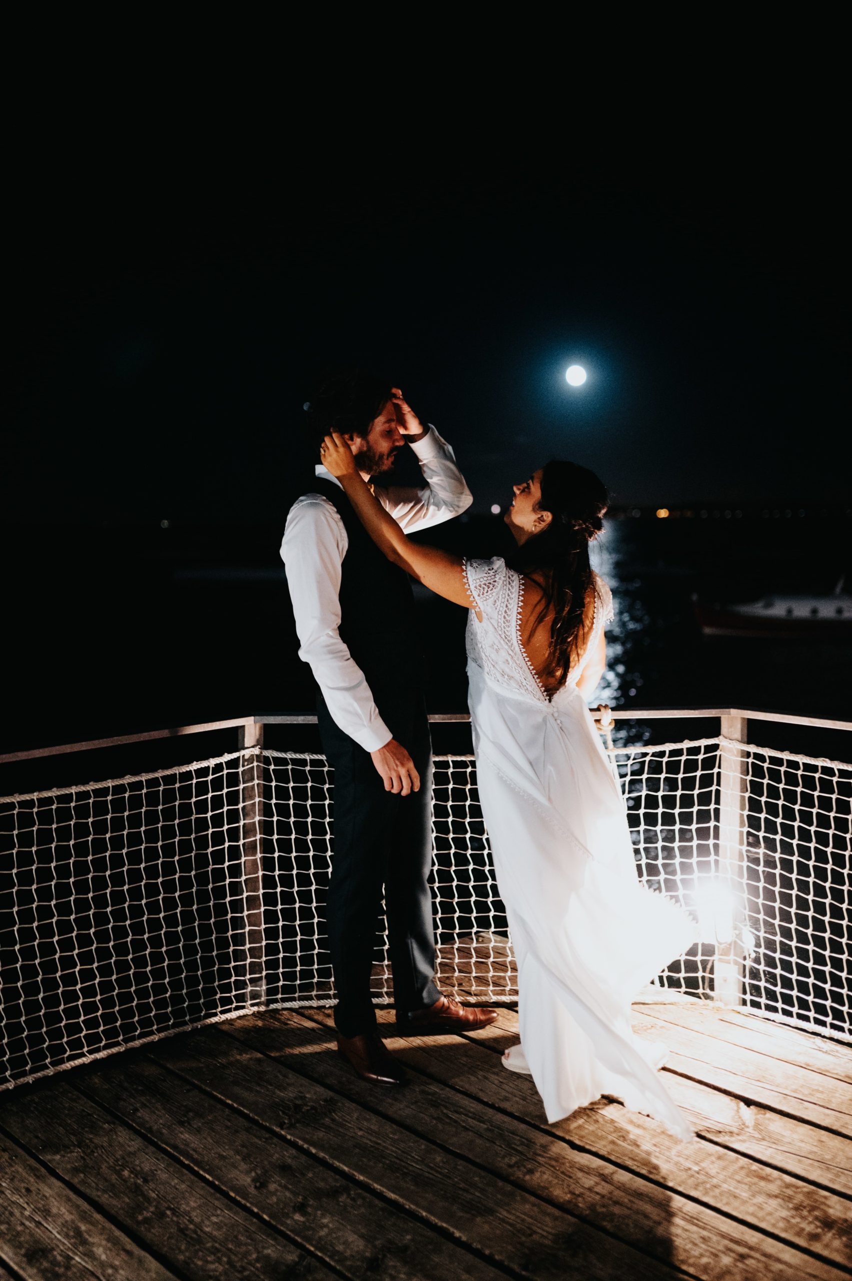 mariée qui recoiffe son amoureux sur un ponton au Cap ferret